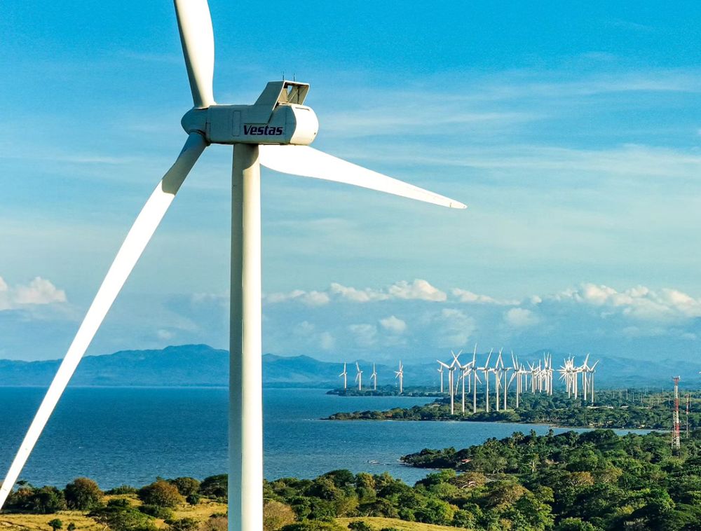 Wind turbine overlooking a lake and a wind farm